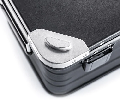 Heavy-duty stacking corners in cast aluminum, mounted with sturdy rivets.